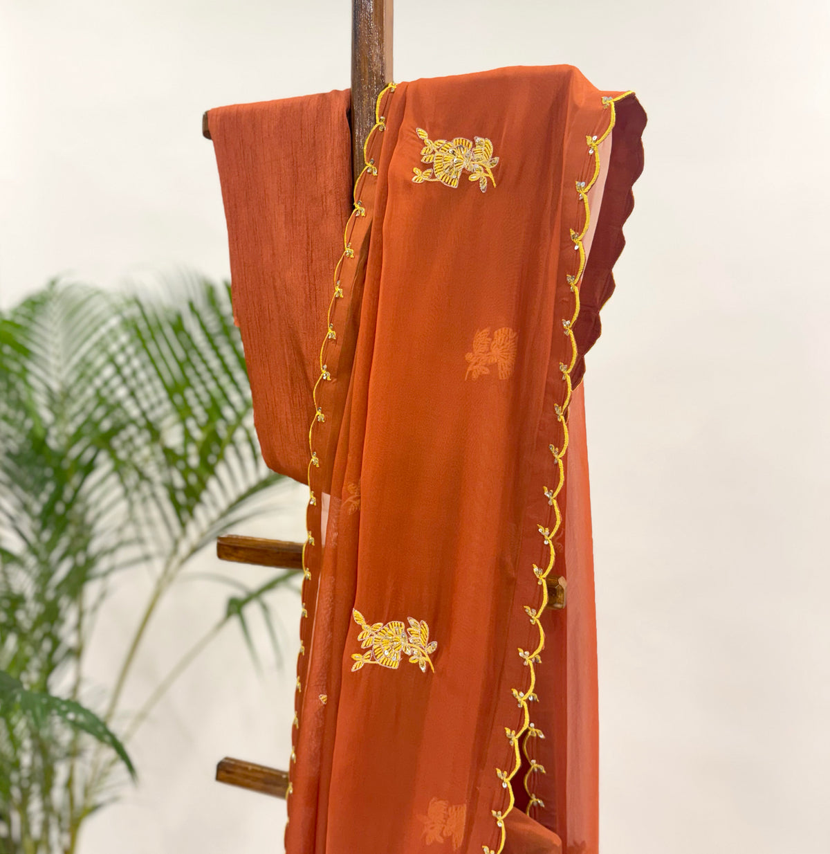 RUST FALLING ORGANZA SAREE WITH THREAD MOTIFS AND UNSTITCHED BLOUSE FABRIC