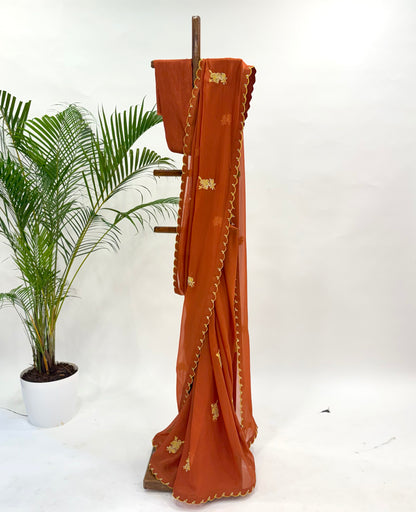 RUST FALLING ORGANZA SAREE WITH THREAD MOTIFS AND UNSTITCHED BLOUSE FABRIC